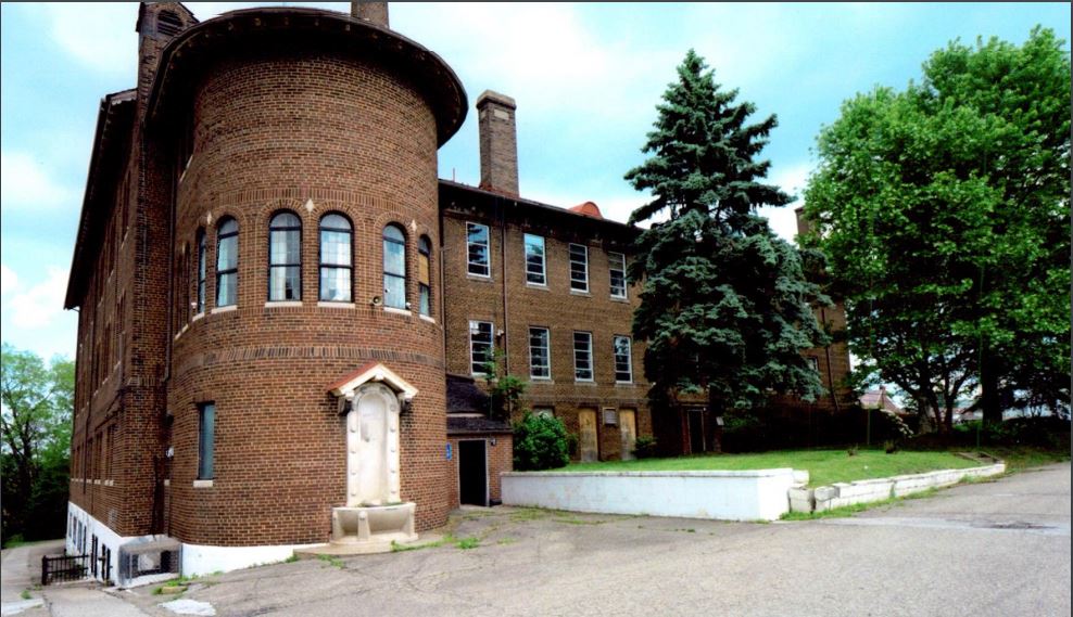 Three-story brick building with rounded corner.