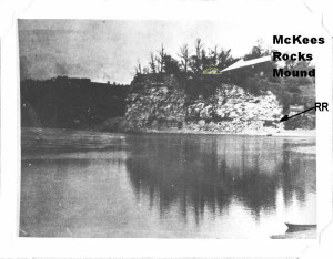 Location of McKees Rocks Mound on the bluff overlooking the mouth of Chartiers Creek with the Ohio River in the foreground.  This photograph was taken in 1896 and is used courtesy of the Section of Anthropology of Carnegie Museum of Natural History.  It was taken from either from a boat or Brunot’s Island in the Ohio River.  The white arrow was added by the excavators.  There is a train track at the base of the bluff.  The author added the mound outline, dark arrow pointing to the railroad line and mound label.
