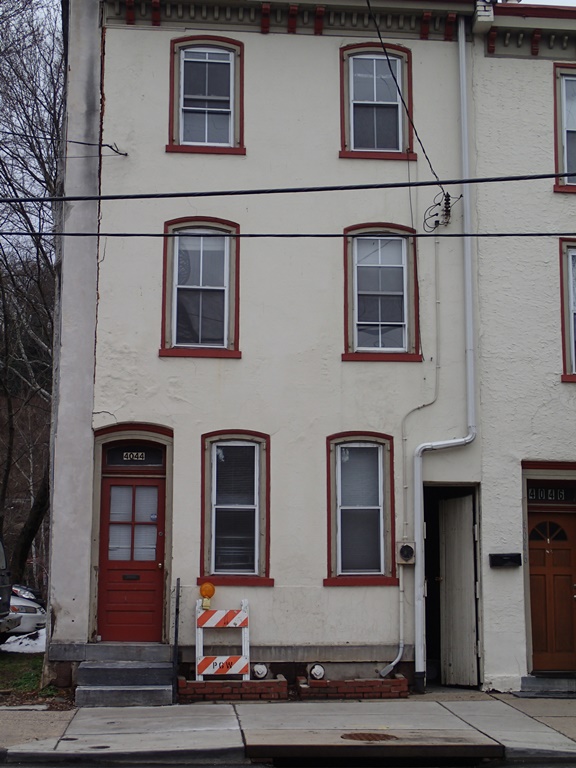A flood-damaged, vacant rowhouse on the south side of Main Street in the Manayunk Historic District.