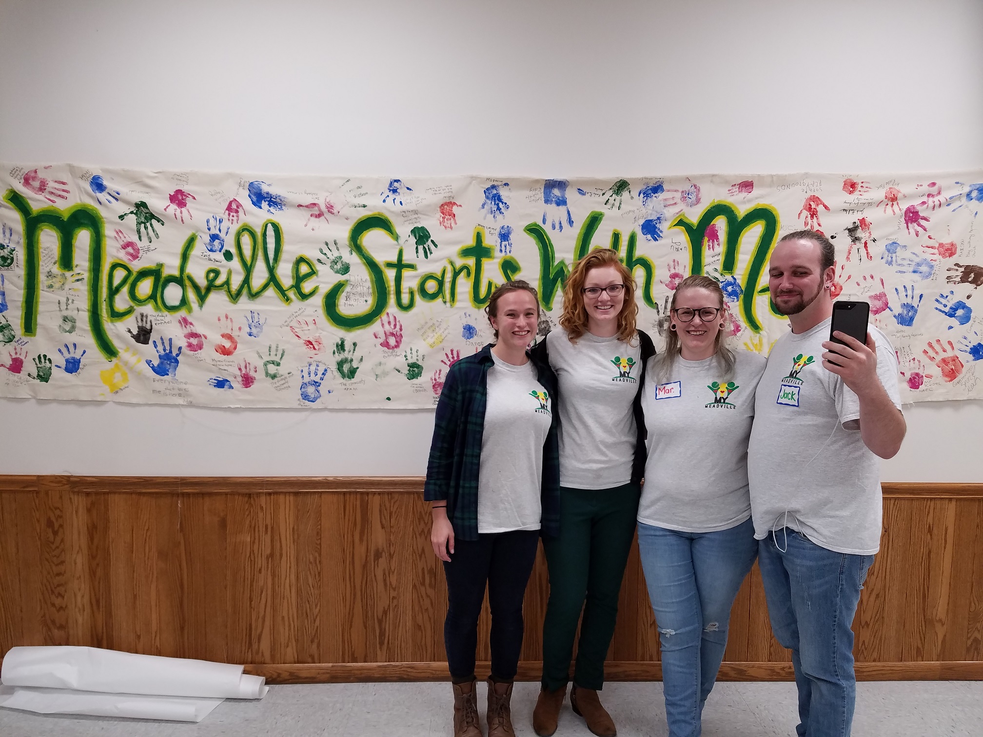 The My Meadville leadership team poses alongside the project’s catchphrase, “Meadville starts with me.” Used by permission.