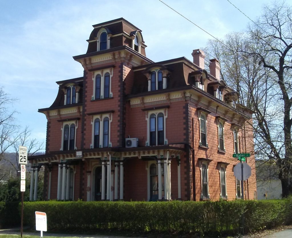 Photograph of two-story brick Second Empire house with mansard roof and central tower.