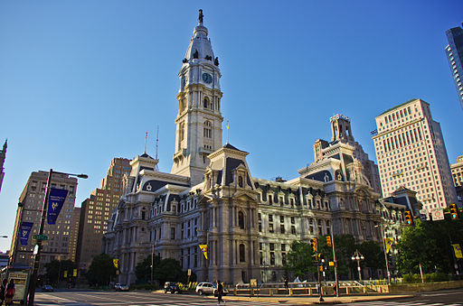 Picture showing large stone public building with tall tower, with a statue of William Penn at the top.