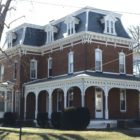 This image shows a two-story brick house with mansard roof.