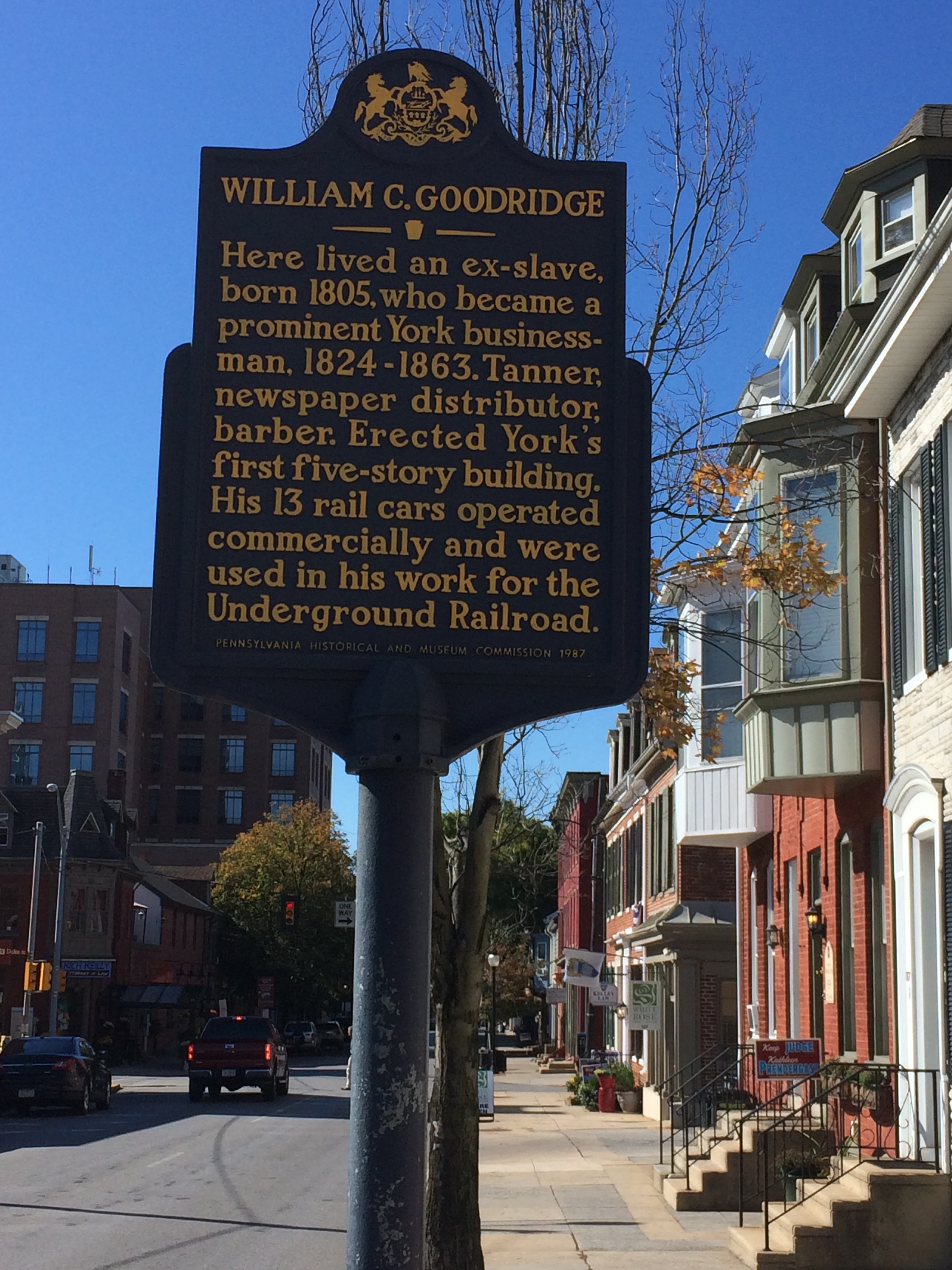 This photo shows the tall, metal blue and gold marker for William C. Goodridge.
