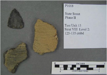 Cord-marked, grit-tempered ceramic sherds of Mahoning Ware and a triangle point recovered from the Ashton Cemetery Site (36LR0165).