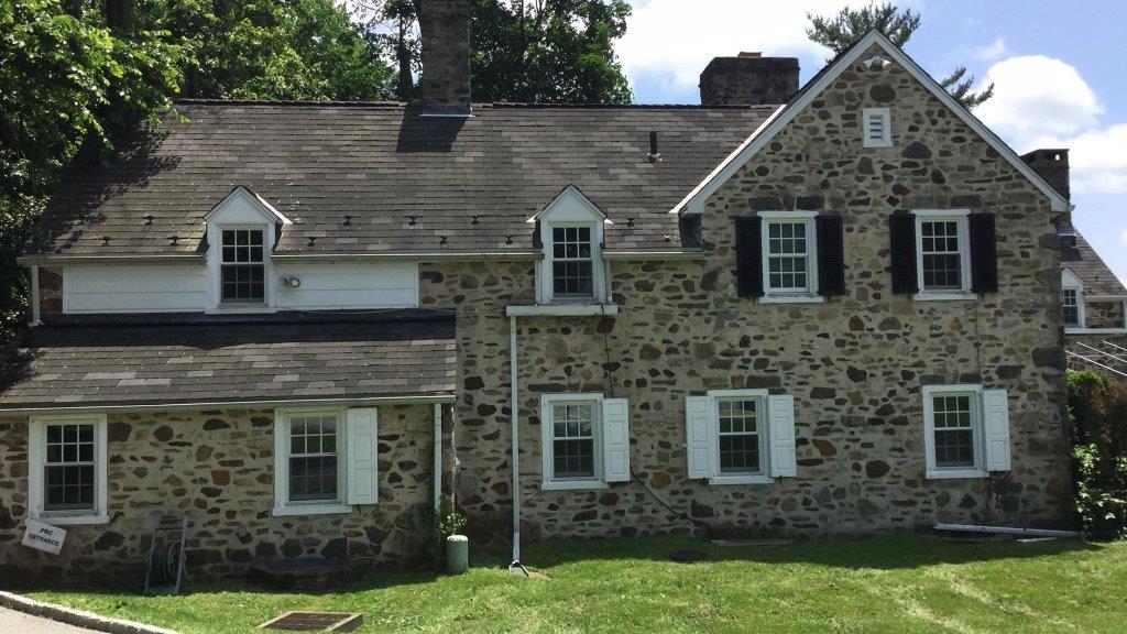 Large stone Colonial Revival house.