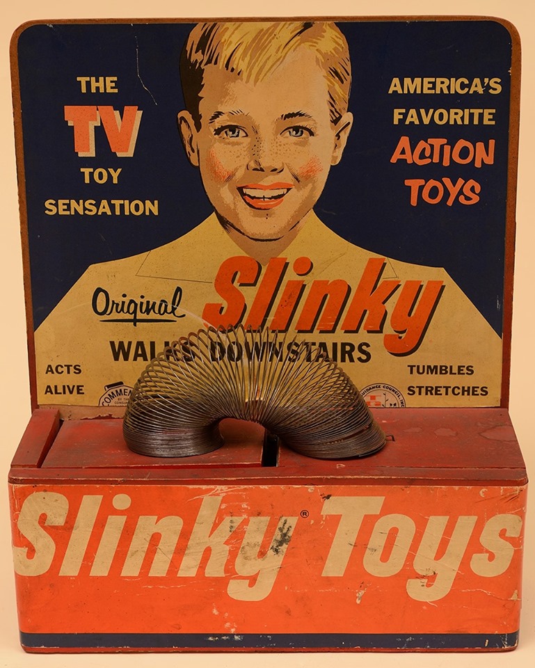 Advertisement for slinky toy showing boy and a slinky.