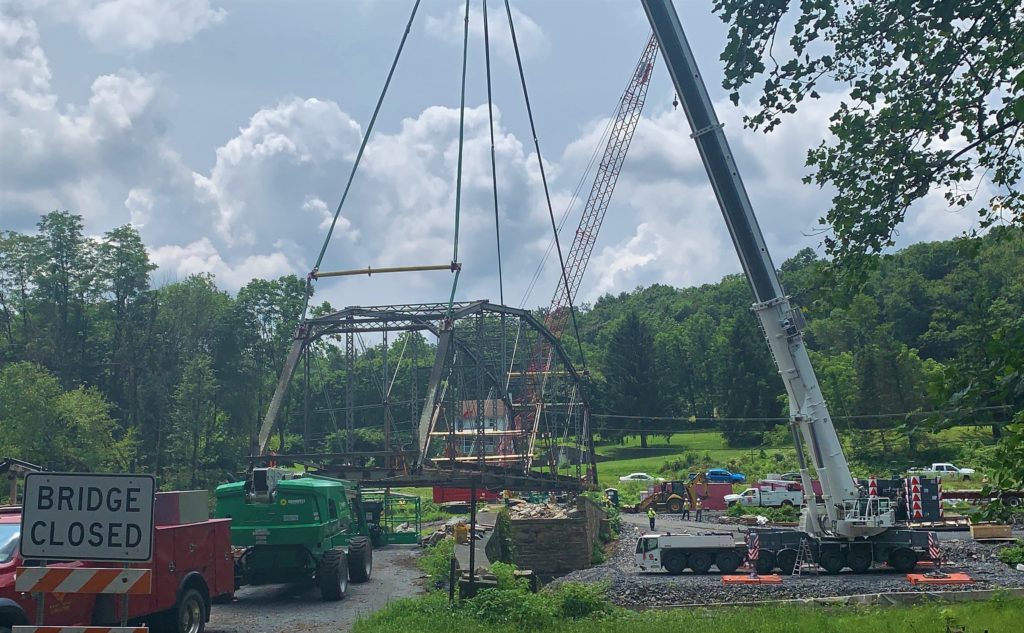 Large cranes connected to a metal truss bridge.