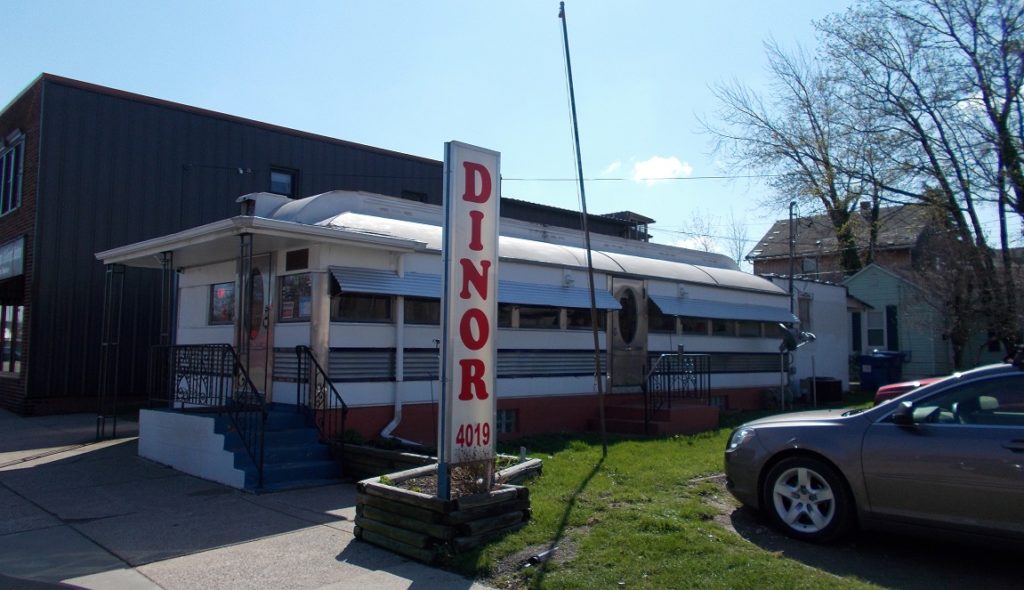 One story metal building with large sign in front that reads "Dinor".