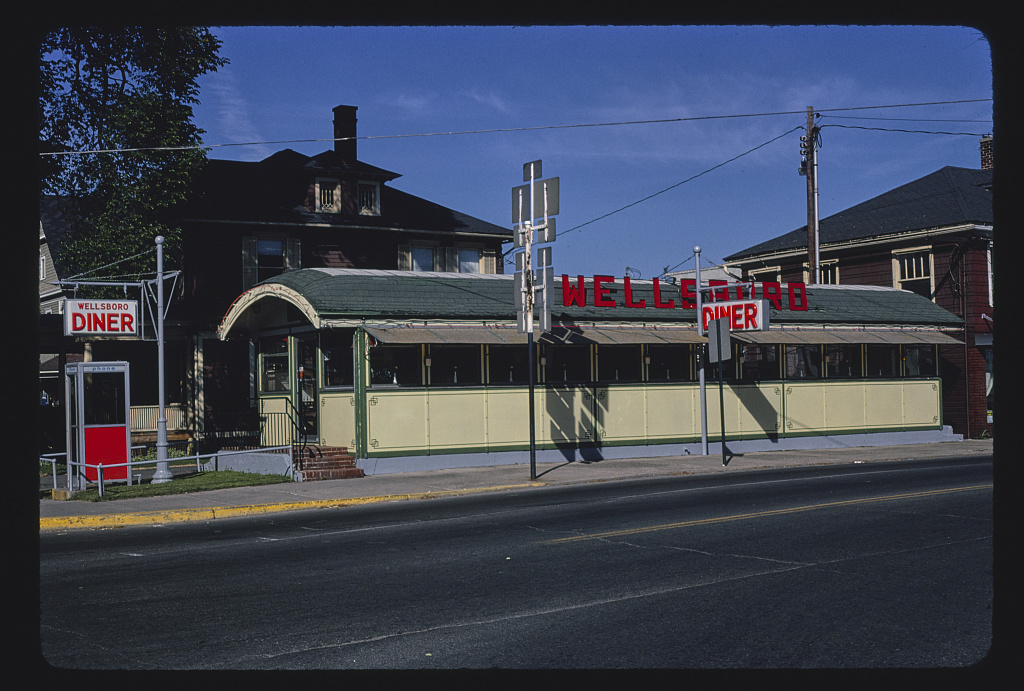 One-story yellow metal building with rounded roof and sign that reads "Wellsboro"