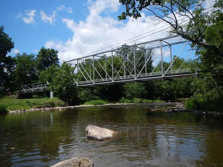 Metal truss bridge over water.