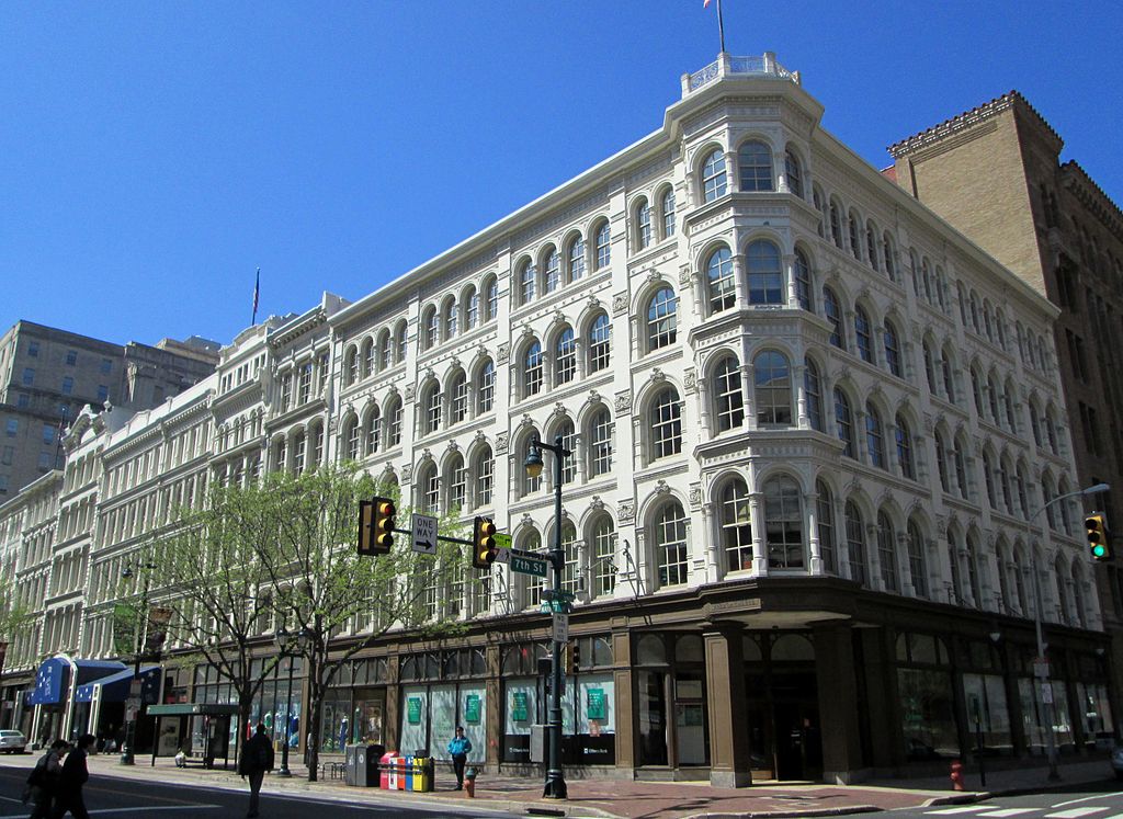 Large five-story building in city block with rows of large arched windows.