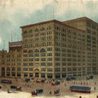 Colorized historic postcard of large department store with trolleys, horses, carts, and people in the foreground.