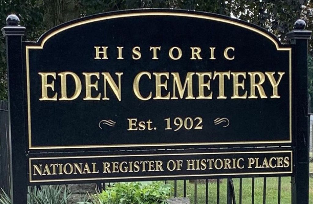 Large black wood sign with gold letters.