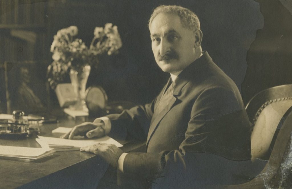 Historic photograph of a man sitting at a desk.