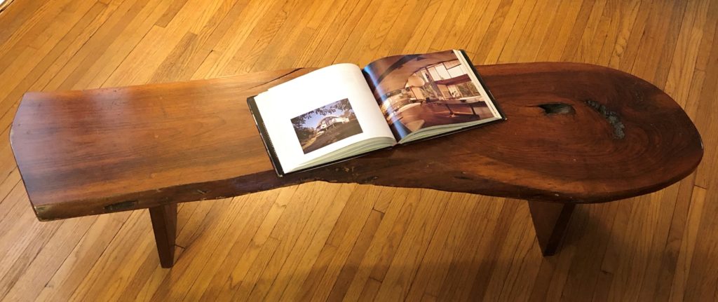 Long, narrow, low wood table with open book on top.