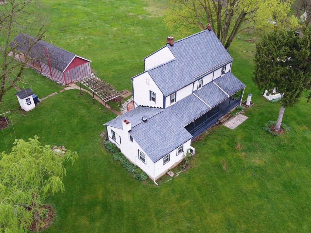 Overhead view of house surrounded by grass.