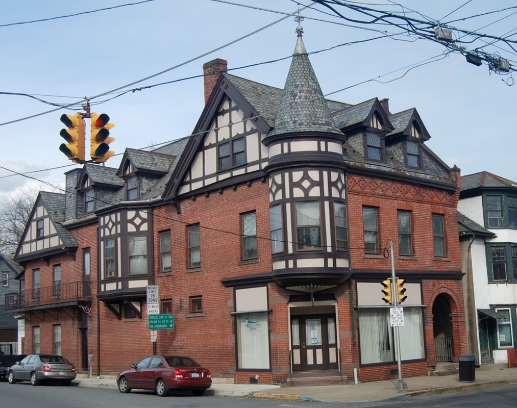 Brick building at intersection of two roads with corner turret.