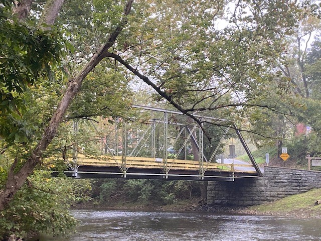 Metal truss bridge over water.