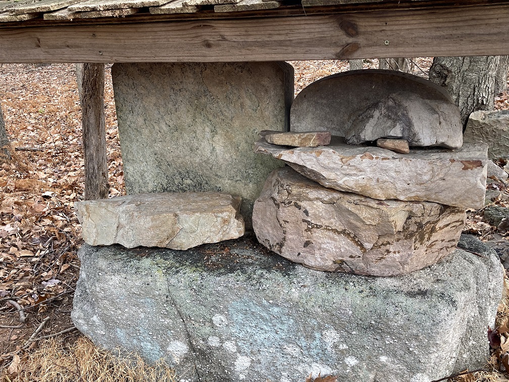 Grouping of stones below small wood enclosure.