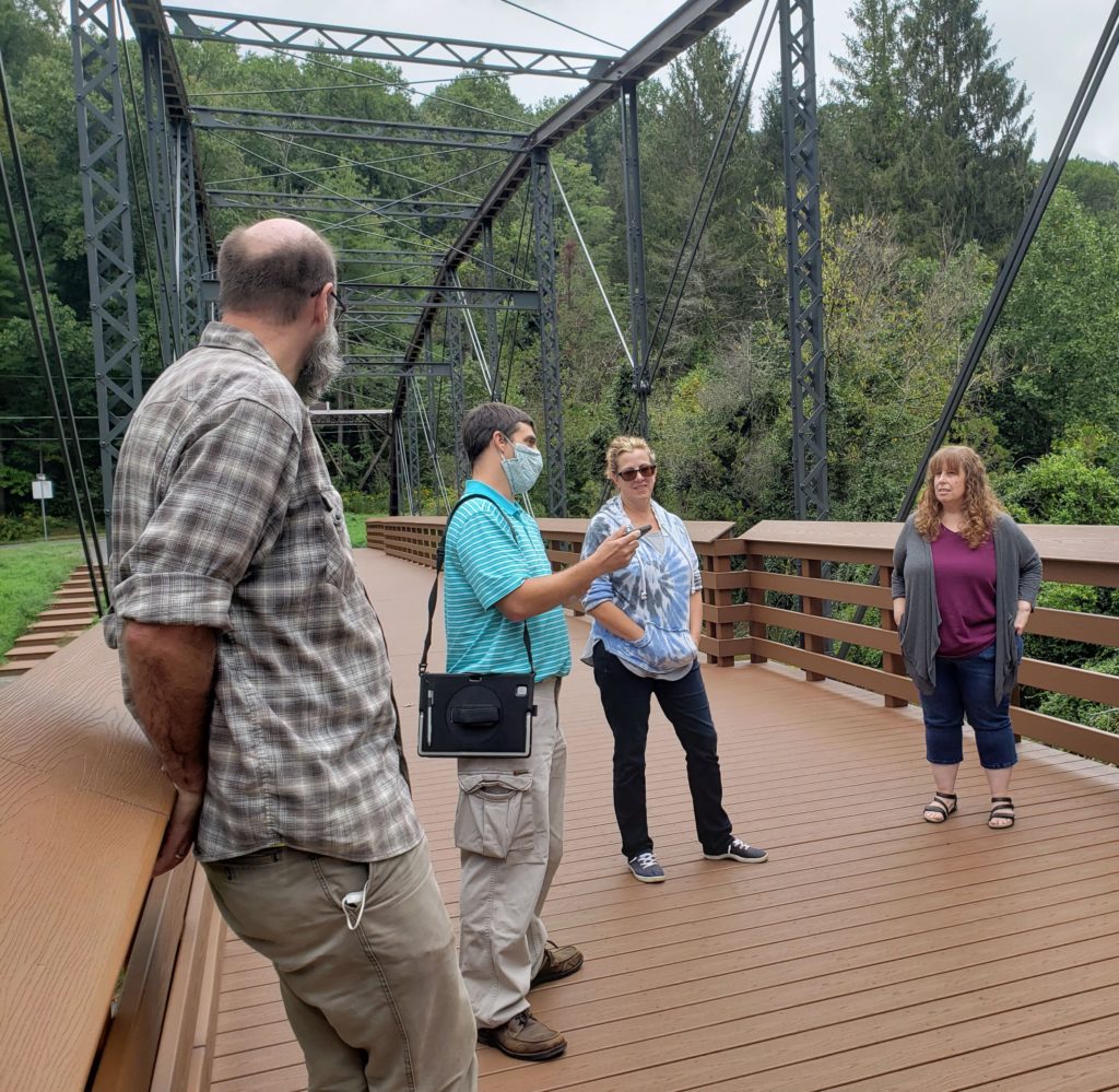 Group of people standing on bridge.