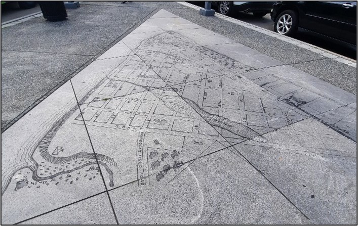 Sidewalk with lines and shapes depicting a map.