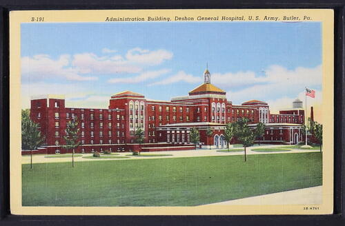 Color postcard of large brick building with landscaping in front.