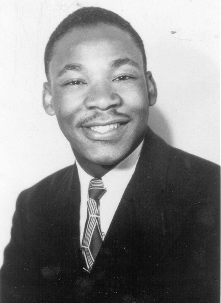 Black and white photograph of a Black man wearing a suit and tie.