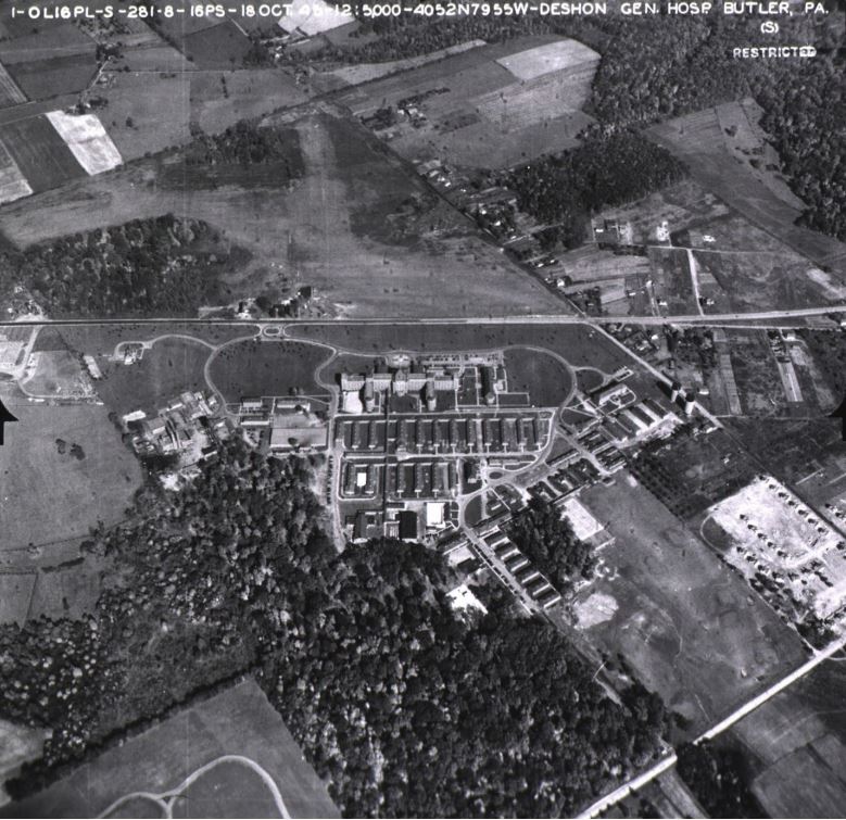 Black and white aerial photograph of large building campus.