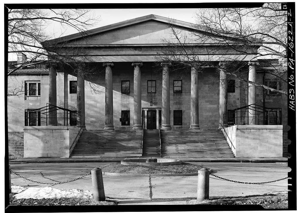 Black and white photograph of a 2-story stone building with columned porch.