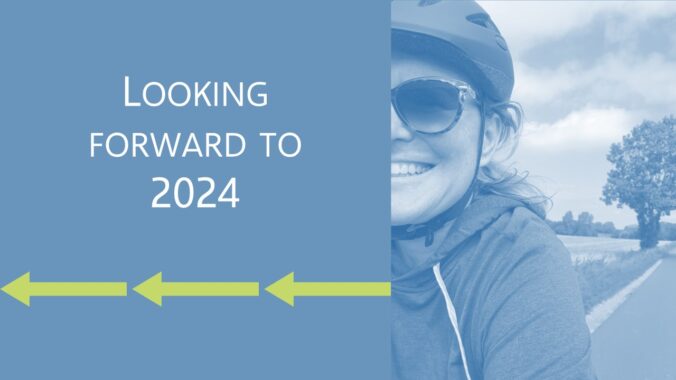 Head and shoulders image of a woman on a bike along with the words "looking forward to 2024" above three green arrows.