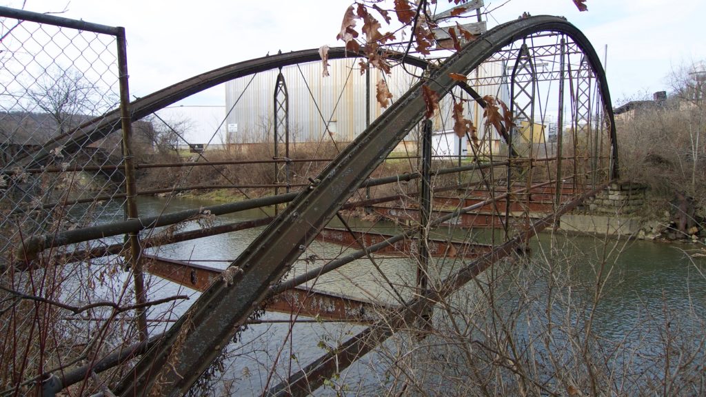 Metal bridge with no floor over water.