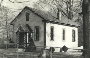 Black and white photo of one story wood building.
