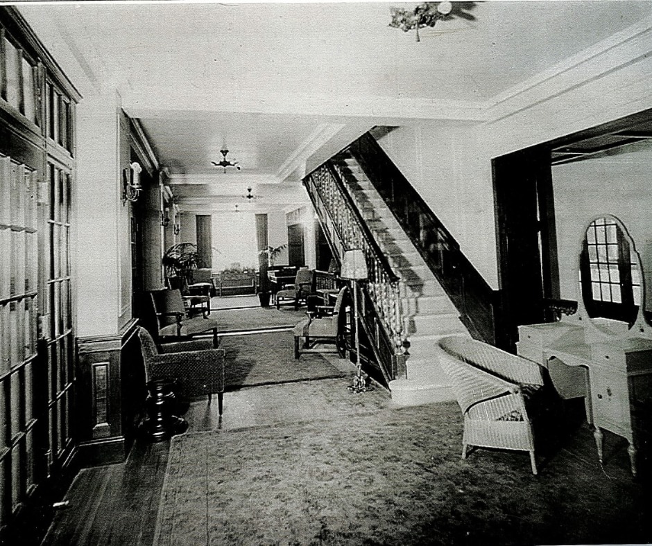 Black and white photo of inside room with furniture.