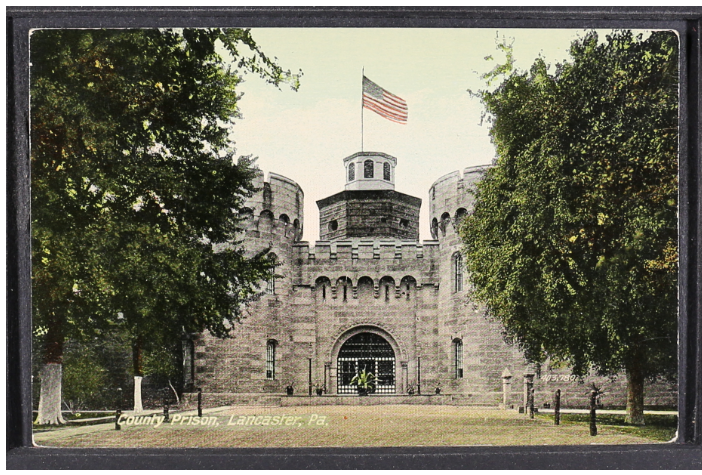 Historic postcard showing stone prison with flag on top and trees to either side.
