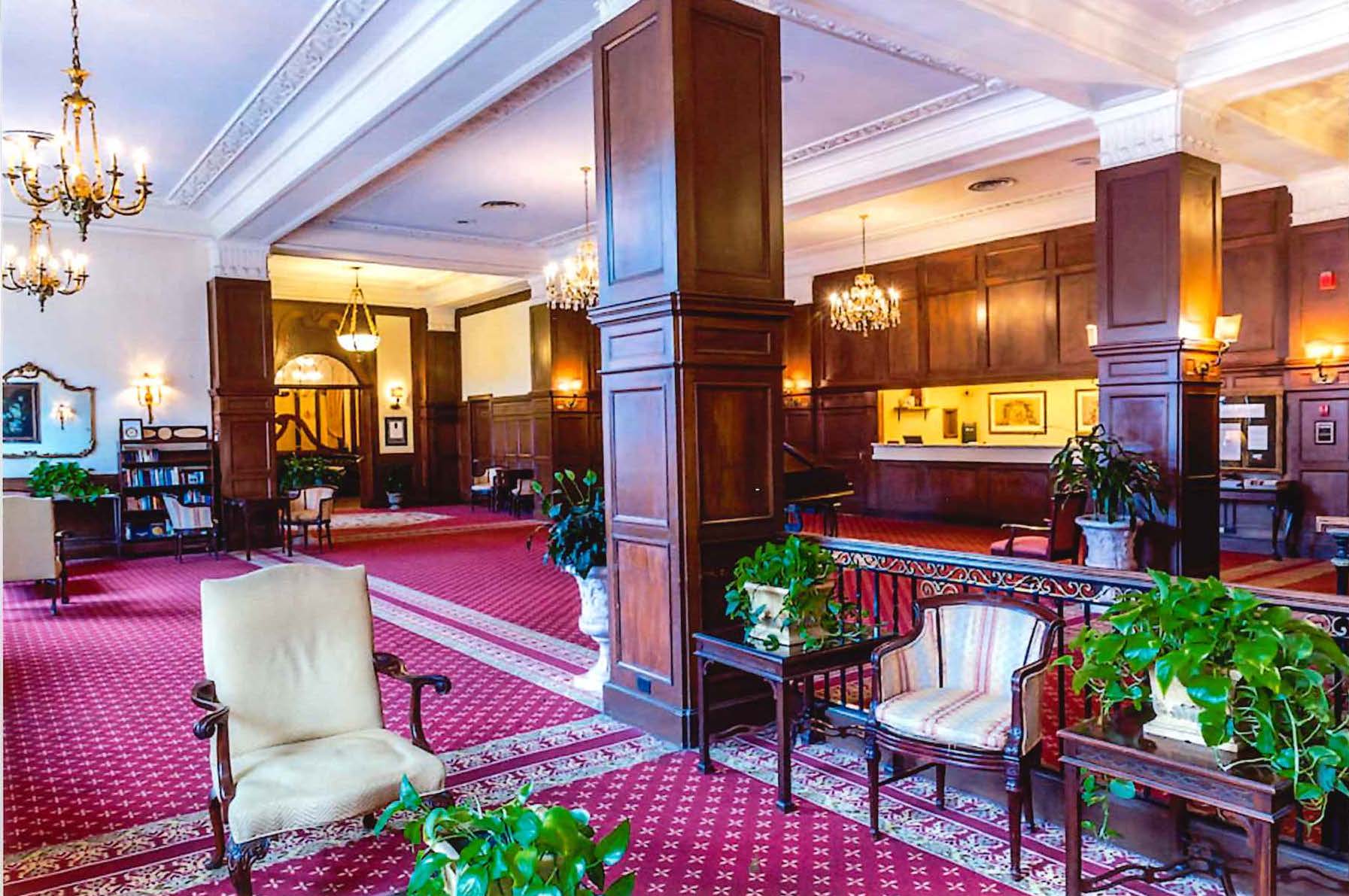 Hotel lobby with chairs, carpeting, and large columns.