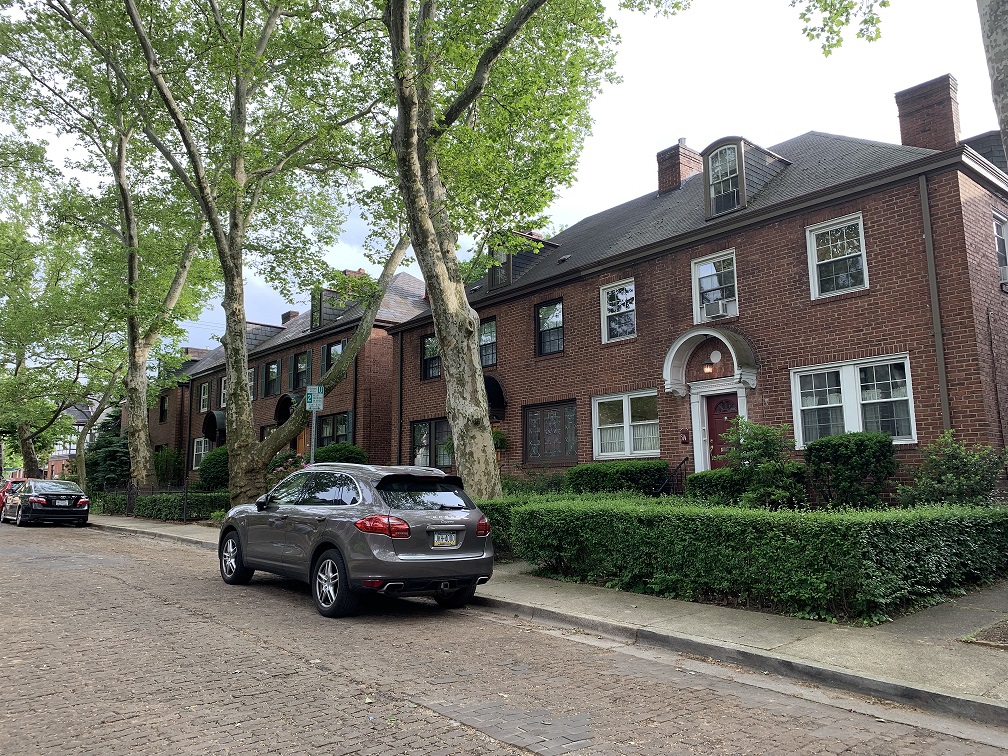 Row of two-story brick houses along a brick road.