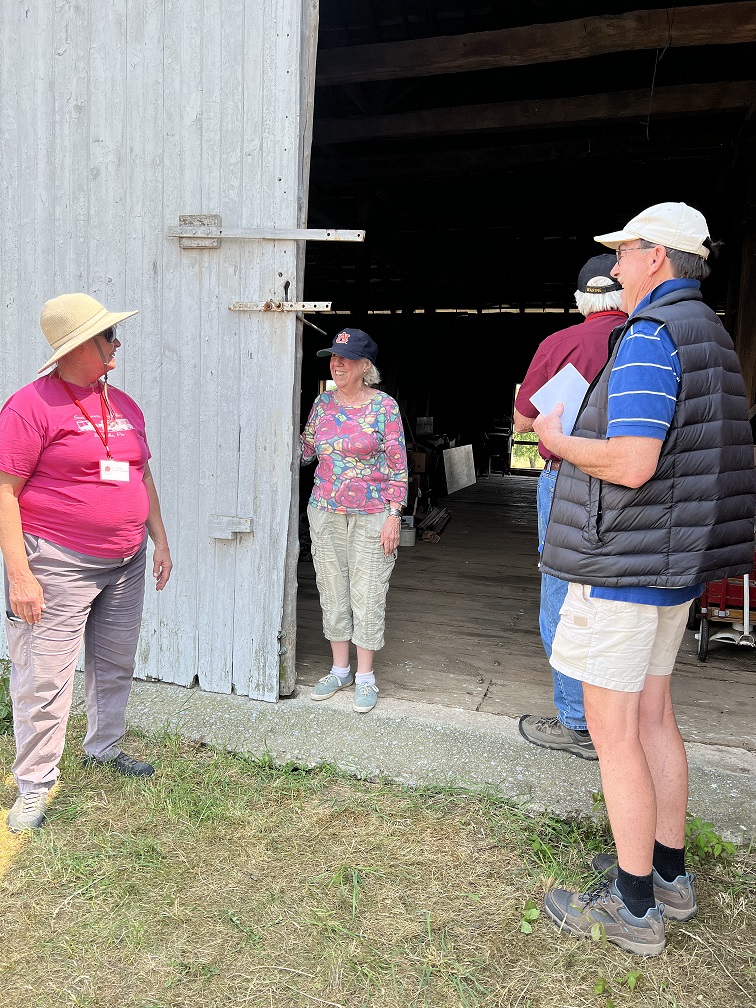 Small group of people standing in large barn door opening.