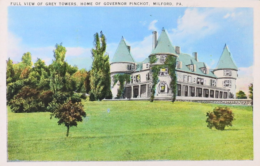 Historic color postcard of large building surrounded by lawn.