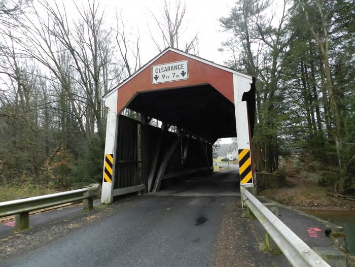 Road through wood covered bridge.