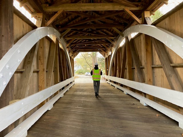 Person walking through covered bridge.
