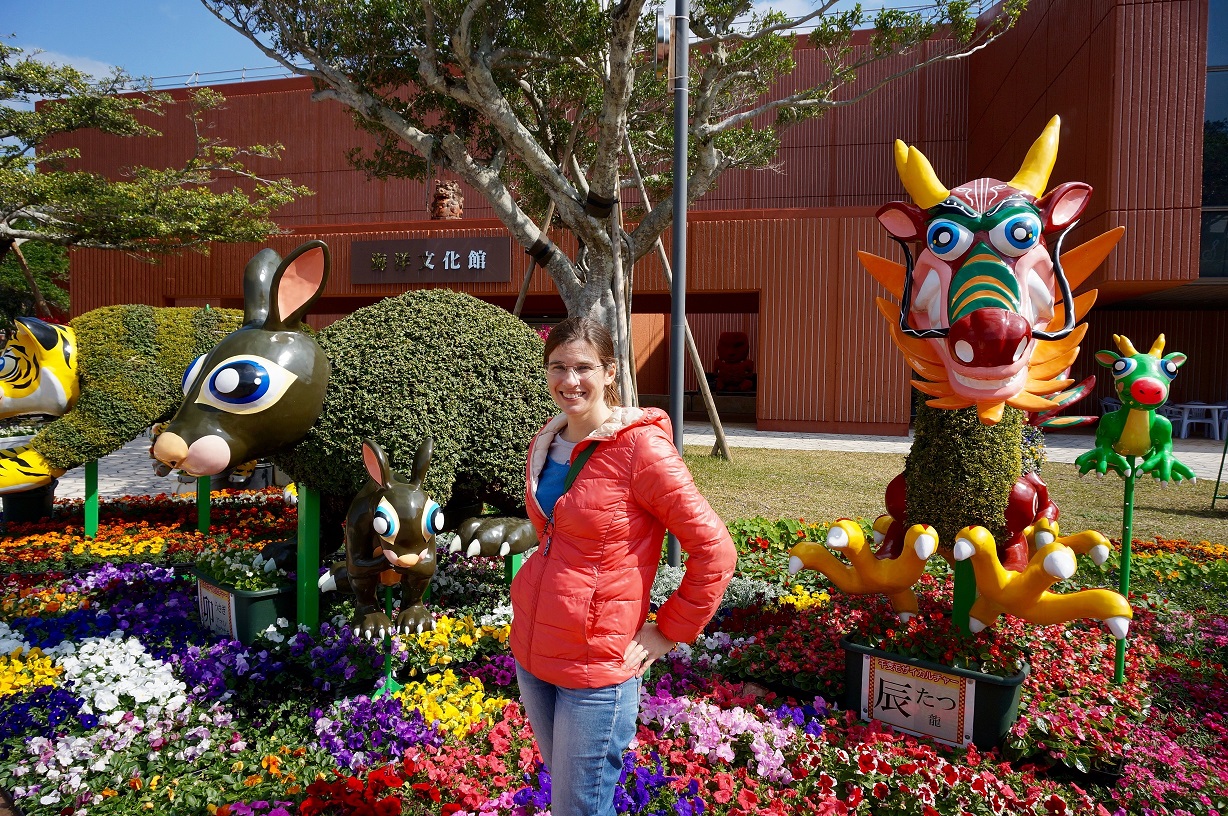White woman standing in garden with animal statues.