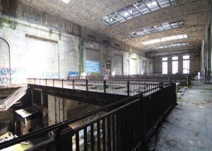 Large industrial space with stairs and graffiti.