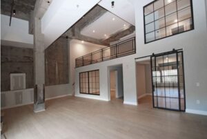 Large room with concrete column and interior window walls.