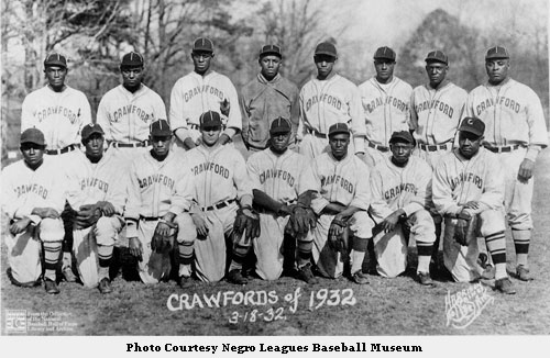 Group of African American men wearing baseball uniforms organized in two rows, the front kneeling and the back standing.