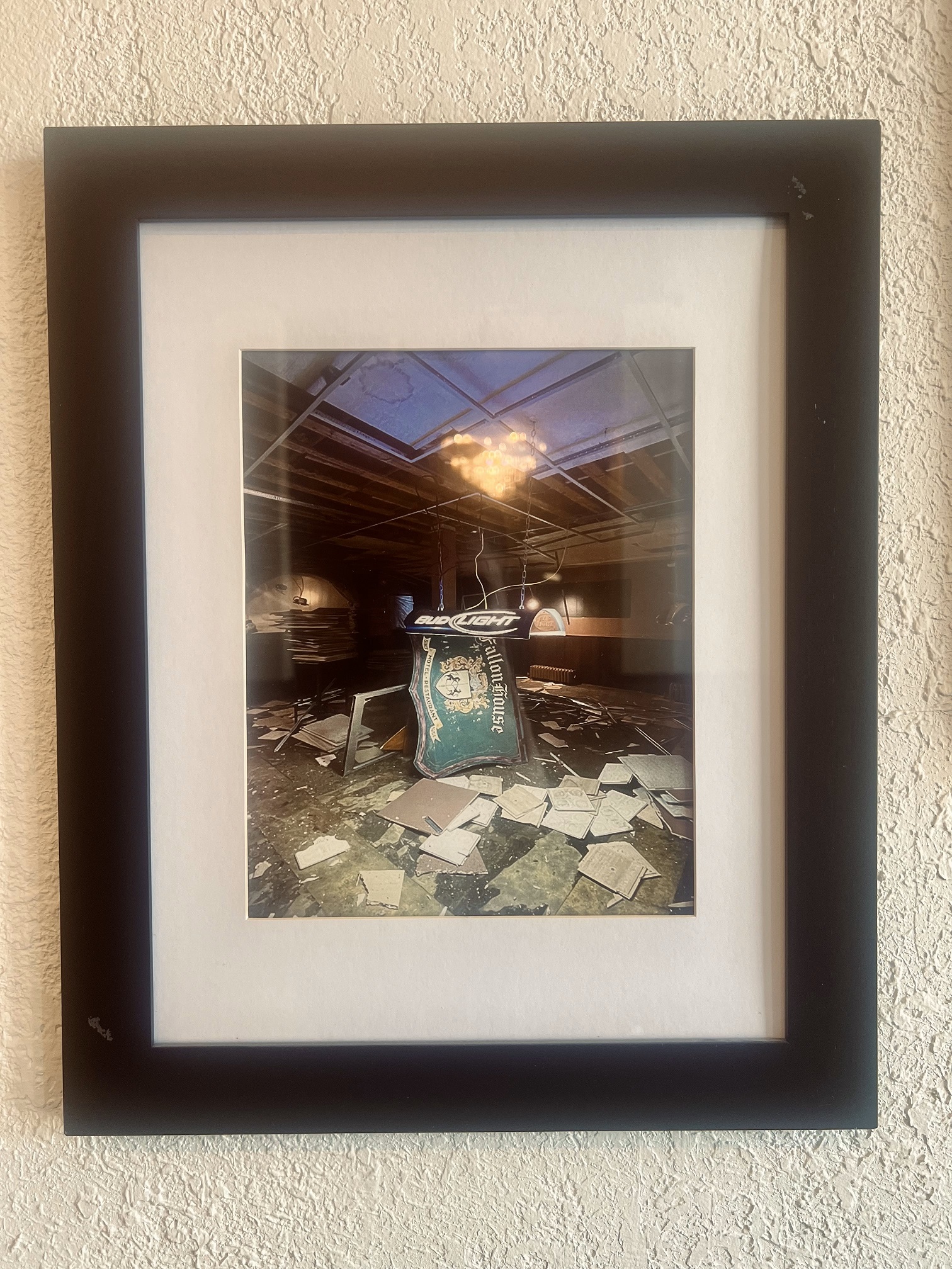 Framed photograph of a room with debris on the floor.