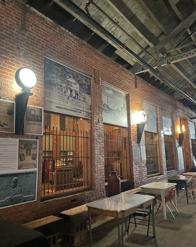 Information panels and old advertisements attached to a brick wall and in openings.