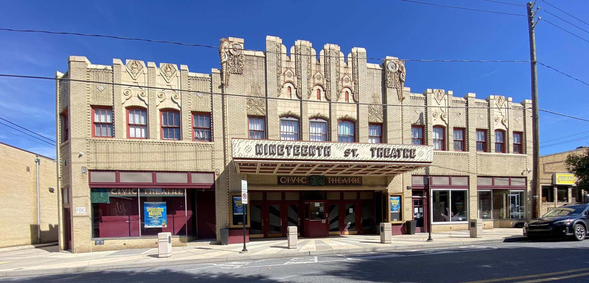 Two story brick building with decorative cast stone upper floor.