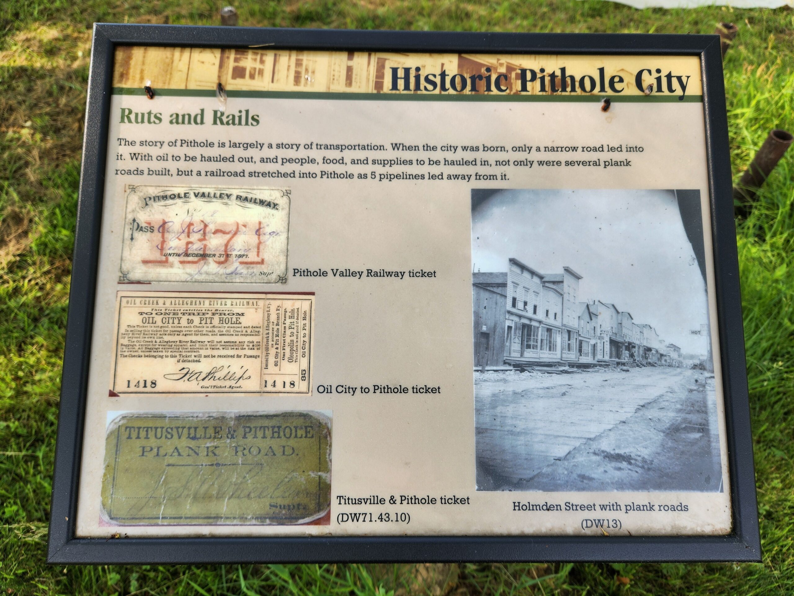 Outdoor plaque with pictures and text in a black frame.