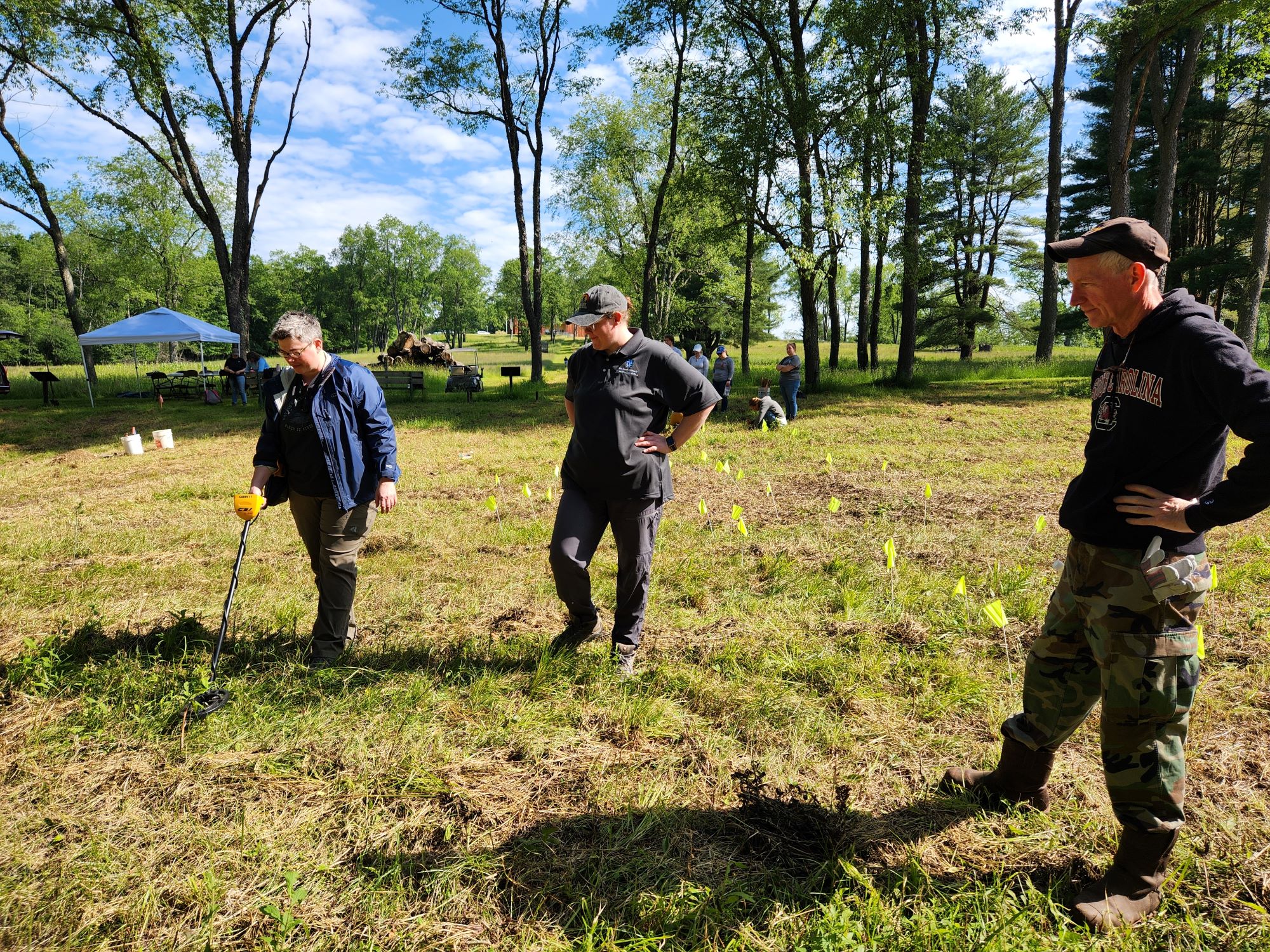 Three people standing in a field.